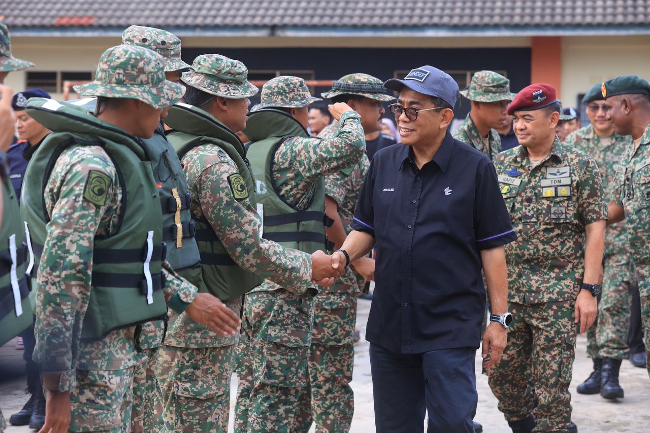 Mohamed Khaled tiga dari kanan bersalaman dengan anggota ATM yang menyertai Ops Murni Banjir Kelantan di SK Gual Tinggi Rantau Panjang hari ini. FOTO oleh KAMARUL BISMI KAMARUZAMAN